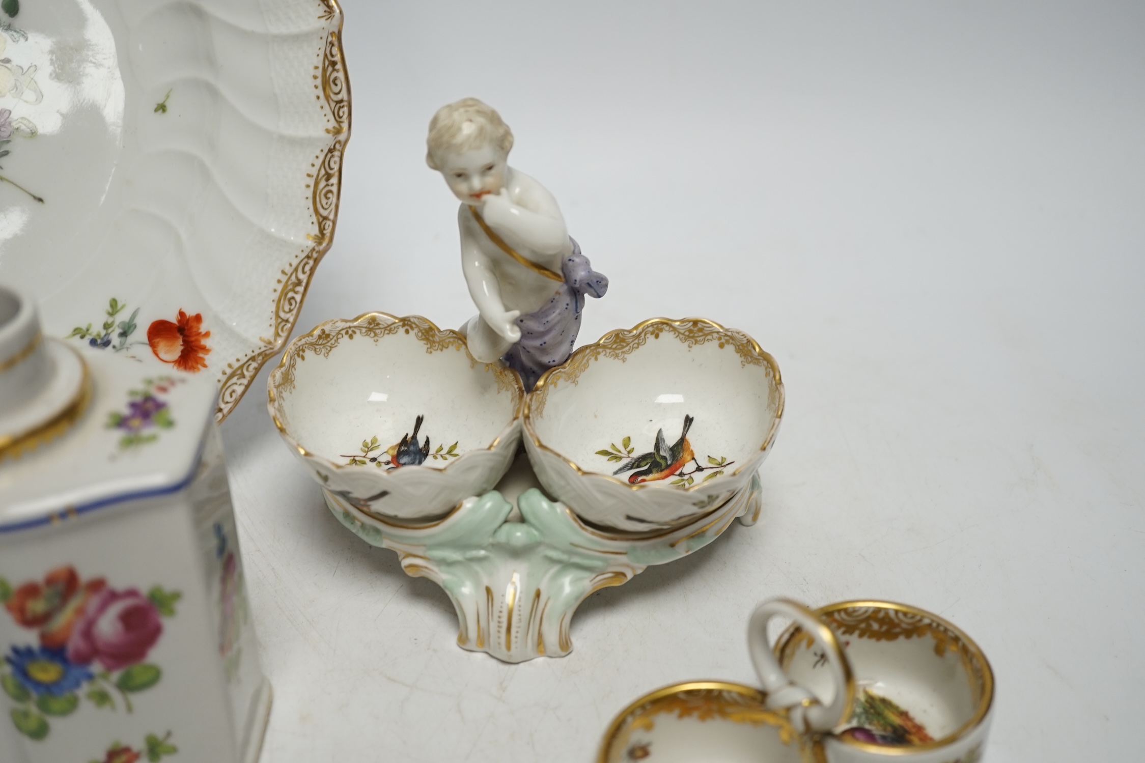 A group of Berlin and German porcelain: a plate, two salts, a figure and a tea canister, tallest figure 13.5cm high